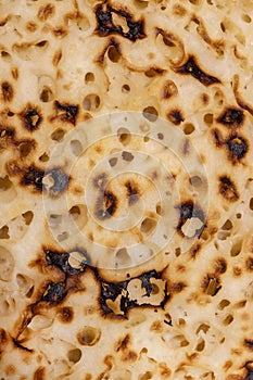 Close-up image of a crumpet or pikelet background backdrop.