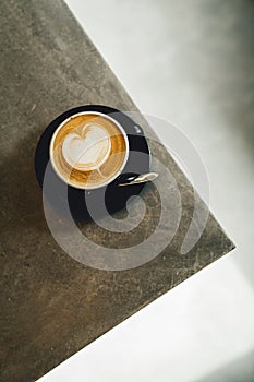 Close-up image of a cup of freshly brewed coffee with intricate latte art poured on top