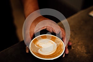 Close-up image of a cup of freshly brewed coffee with intricate latte art poured on top