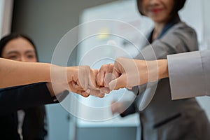 Close-up image of diverse businesspeople are giving fist bump in the meeting. team building