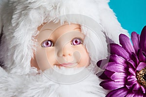 Close up image of doll head with furry cap.