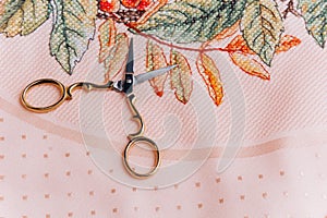 Close-up image of embroidery hoops with floral design and scissors in gold color, perfect for illustration of handmade photo