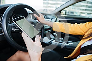 Close up image with female driver and blank phone screen