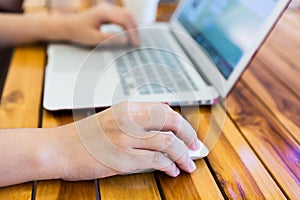 Close-up image of female hand writing on laptop