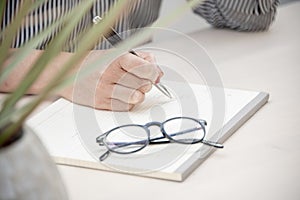 Close up image of a female hand writing in a note book