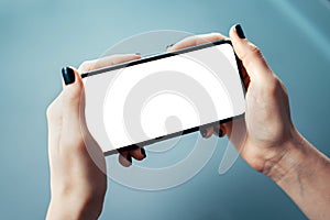 Close-up image of female holding smartphone horizontally with both hands at the office or corporate environment. Human resources,