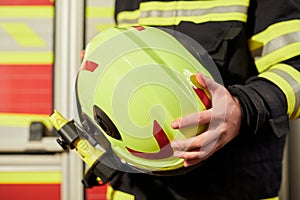 Close up image of a firefighter`s helmet. Firefighter holding a yellow helmet