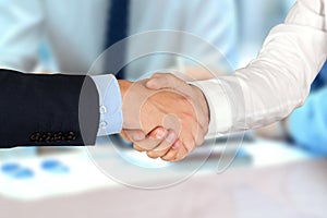 Close-up image of a firm handshake between two colleagues in of