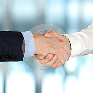 Close-up image of a firm handshake between two colleagues in of