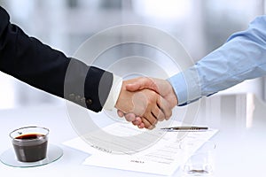 Close-up image of a firm handshake between two colleagues in of