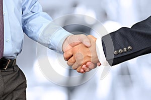 Close-up image of a firm handshake between two colleagues in off