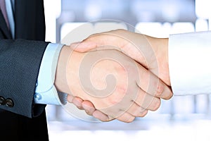 Close-up image of a firm handshake between two colleagues outsi