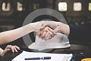 Close-up image of a firm handshake between two colleagues after signing a contract.