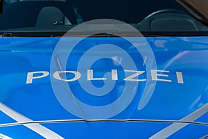 Close-up image of a German police car with white letters and blue background