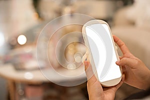 Close-up image of girl sitting in the cafe and using mobile phone. smartphone white screen mockup for display graphic banner