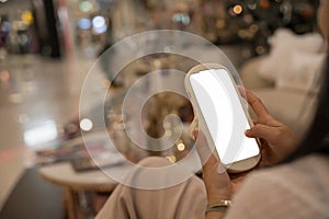 Close-up image of girl sitting in the cafe and using mobile phone. smartphone white screen mockup for display graphic banner