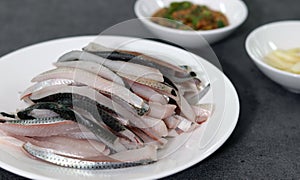 Close-up image of gizzard shad sashimi on plate.