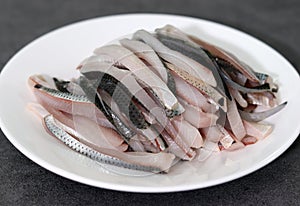 Close-up image of gizzard shad sashimi on plate.