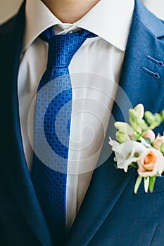 Close-up image of a groom in a blue tie. Artwork. Selective focus on the ornament tie