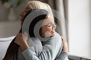 Close up image grown up daughter hugging elderly mother