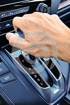 Close-up image of a hand on a car gear shifter.