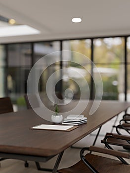 Close-up image of a hardwood meeting table in a modern spacious meeting room. Business workspace