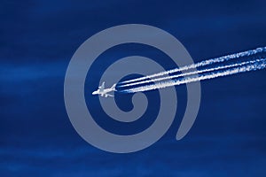Close-up image of a high altitude jet with contrails