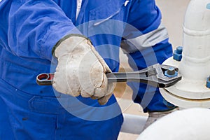 Close-up image of human hand fixing and stop leak flange by wrench