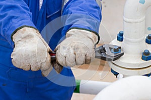 Close-up image of human hand fixing and stop leak flange by wrench