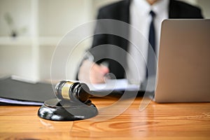 Close-up image of a judge gavel or judge hammer is on a wooden desk in a lawyer office