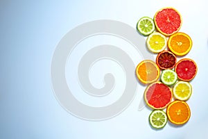 Close up image of juicy organic assorted sliced citrus fruits, visible core texture, bright paper textured background, copy space