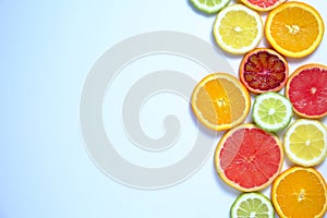 Close up image of juicy organic assorted sliced citrus fruits, visible core texture, bright paper textured background, copy space