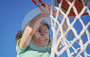 Close up image of kid basketball player making slam dunk during basketball game, stock photo. Banner  on sky