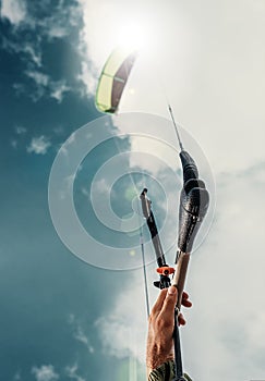 Close up image kitesurfer hand with kite in blue sky