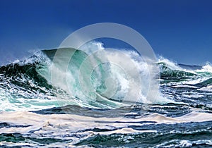 Close-up image of large ocean wave crashing near shore line