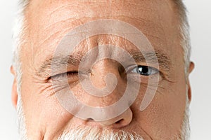 Close-up image of male face with blue eyes looking at camera. Vision care. Mature model with wrinkles on forehead