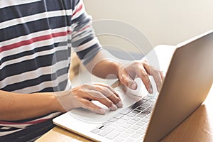 Close-up image of male hands working on laptop