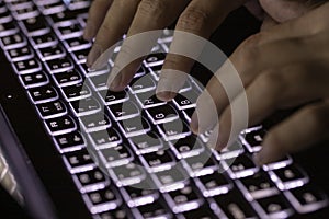 Close-up image of male hands working on laptop