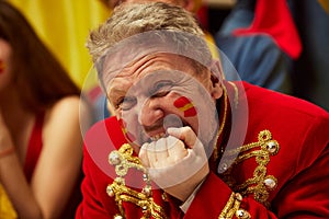 Close-up image of man, football, soccer fans emotionally watching match, worrying about favourite team. Fans wearing