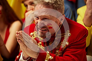 Close-up image of man, football, soccer fans emotionally watching match, worrying about favourite team. Fans wearing