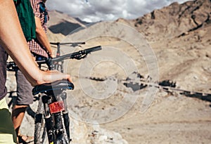 Close up image man hand on bicycle saddle. Two maountain bikers