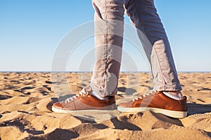 Close up image of man legs walking alone sandy beach with blue ocean and white sand,