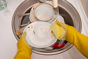 Close-up image of man Washing stack of dishes.