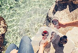 Close up image man and woman hands with goblet of wine at the se