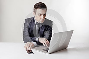 Close up image of multitasking business man using a laptop and mobile phone