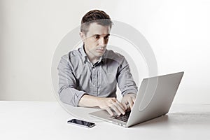 Close up image of multitasking business man using a laptop and mobile phone