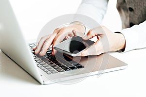 Close up image of multitasking business man using a laptop and mobile phone