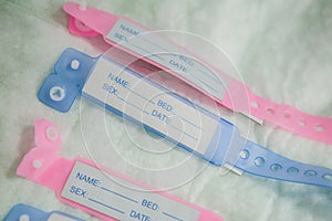 Close-up image with new born babies tags, blue for boys and pink for girls in a maternity