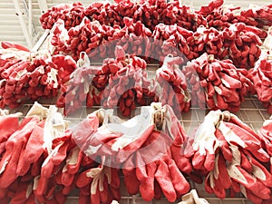 Close up image of new red work gloves from cotton and rubber hang on counter