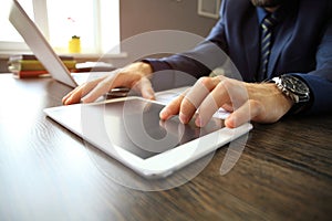 Close-up image of office worker using a touchpad to analyze statistical data